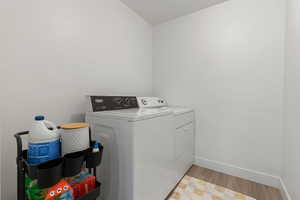 Laundry room featuring light hardwood / wood-style floors and washer and dryer