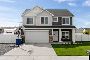 View of front of home with a garage and a front lawn