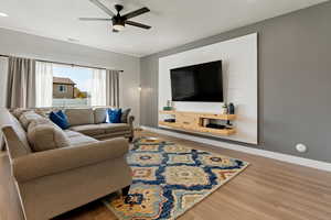 Living room with wood-type flooring and ceiling fan