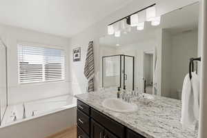 Full bathroom with separate shower and tub, vanity, toilet, and hardwood / wood-style floors