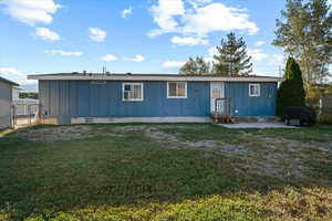 Rear view of house featuring a lawn