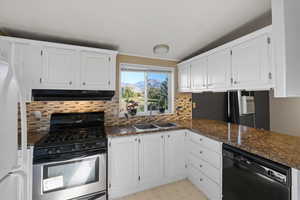 Kitchen with stainless steel gas range, black dishwasher, white cabinets, and sink