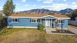 View of front of home featuring a front lawn and a mountain view