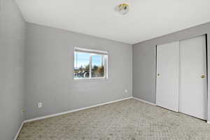 Unfurnished bedroom featuring light colored carpet and a closet