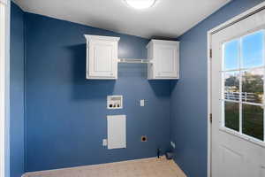 Laundry room featuring hookup for a washing machine, hookup for an electric dryer, a textured ceiling, cabinets, and ornamental molding