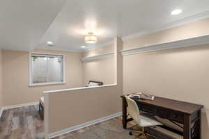 Office with light wood-type flooring, crown molding, and a textured ceiling