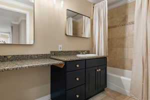 Bathroom with vanity, ornamental molding, and shower / bath combo