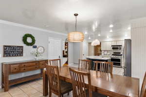 Tiled dining area featuring ornamental molding