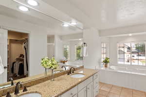 Bathroom with independent shower and bath, vanity, and a wealth of natural light