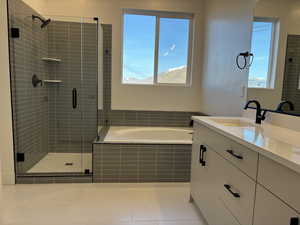 Bathroom featuring shower with separate bathtub and vanity