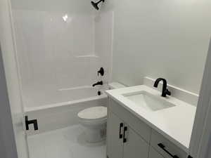 Full bathroom featuring toilet, bathtub / shower combination, vanity, and tile patterned floors