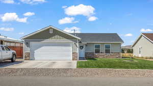 View of front of home with a garage and a front lawn