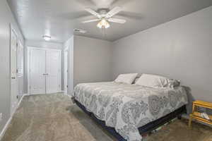 Carpeted bedroom featuring ceiling fan