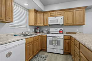 Kitchen featuring light hardwood / wood-style floors, sink, and white appliances