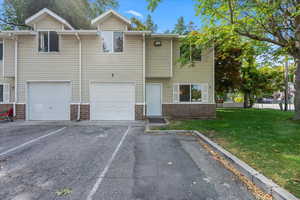 View of front of property with a garage and a front lawn