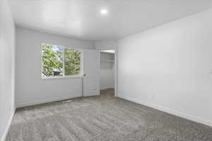 Unfurnished bedroom featuring a closet, carpet floors, and a textured ceiling