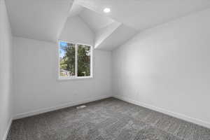 Bonus room with lofted ceiling and carpet flooring