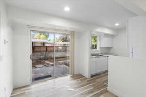 Kitchen featuring light hardwood / wood-style flooring, white cabinetry, and sink