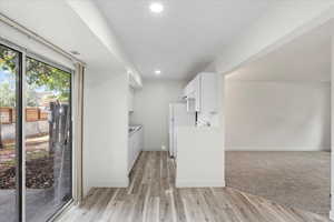 Kitchen featuring light wood-type flooring, white cabinetry, and white refrigerator