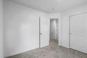 Unfurnished bedroom with light colored carpet