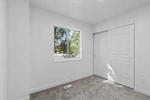 Unfurnished bedroom with a closet and carpet floors