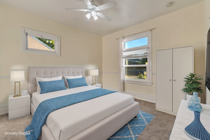 Carpeted bedroom with multiple windows, ceiling fan, and a closet