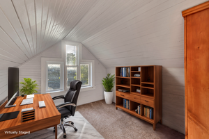 Carpeted home office featuring wooden walls, wooden ceiling, and vaulted ceiling