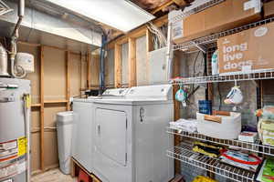 Laundry room featuring gas water heater and separate washer and dryer