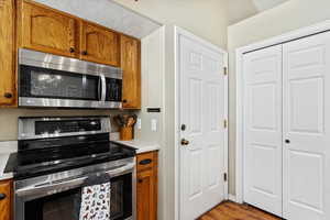 Kitchen with appliances with stainless steel finishes and light hardwood / wood-style flooring