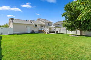 Back of property featuring a yard, a wooden deck, and central AC unit