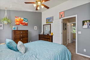 Bedroom featuring carpet, lofted ceiling, and ceiling fan