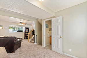 Living room featuring light carpet and ceiling fan