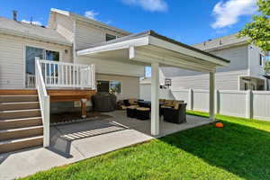 Back of property featuring a patio, a yard, outdoor lounge area, and a wooden deck