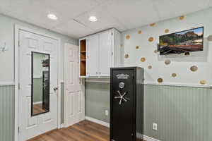 Kitchen with white cabinets, a paneled ceiling, and dark hardwood / wood-style flooring