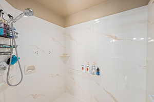 Bathroom featuring a textured ceiling and walk in shower