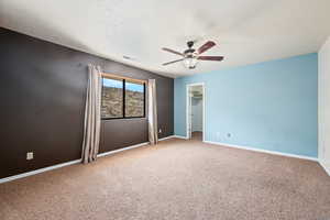 Carpeted spare room with ceiling fan and a textured ceiling