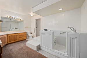 Bathroom featuring vanity, a bathing tub, toilet, and a textured ceiling