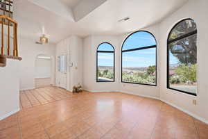 Entrance foyer with a textured ceiling and light tile patterned flooring