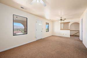 Foyer entrance featuring a textured ceiling, carpet, and ceiling fan