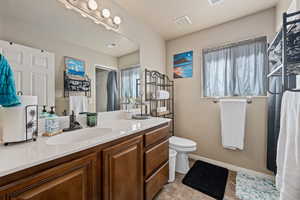 Bathroom featuring a healthy amount of sunlight, vanity, and toilet