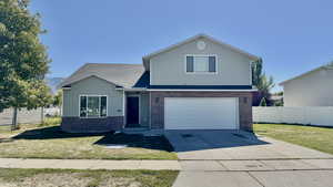 Front of property featuring a front lawn and a garage