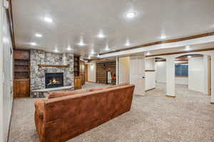 Living room with light carpet, ornamental molding, and a fireplace