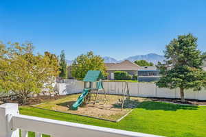 View of jungle gym featuring a lawn and a mountain view