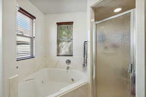 Bathroom featuring plus walk in shower and plenty of natural light