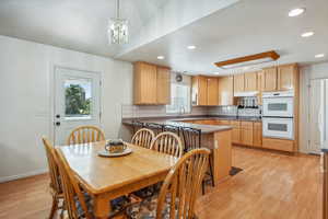 Dining space featuring a notable chandelier, light hardwood / wood-style flooring, and plenty of natural light