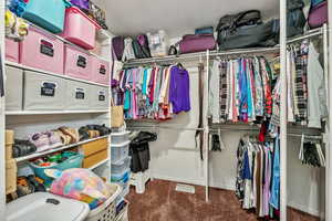 Walk in closet with dark colored carpet