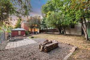 Yard at dusk with a patio area and an outdoor fire pit