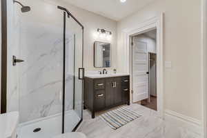 Bathroom featuring walk in shower, vanity, and toilet