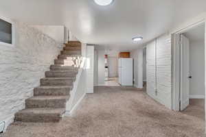 Stairway featuring a baseboard radiator and carpet floors