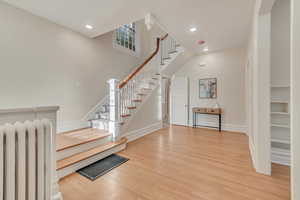 Entryway featuring radiator heating unit and hardwood / wood-style flooring